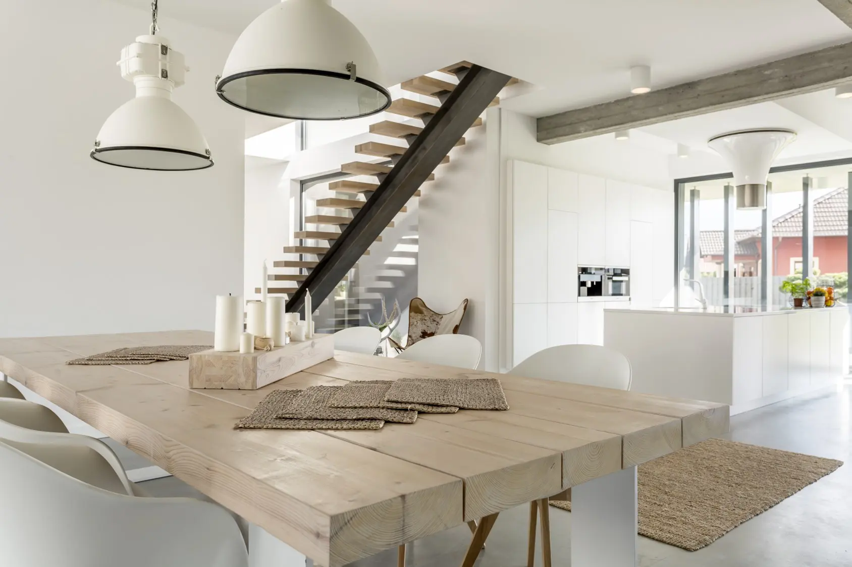 Bright modern dining area with floating staircase