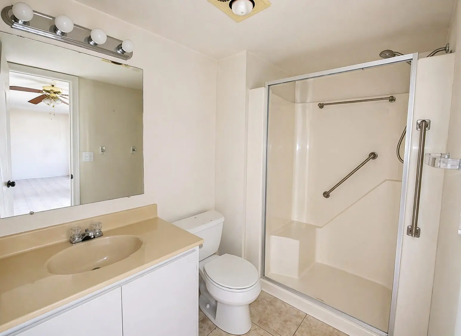 Beige bathroom with vanity, toilet, walk-in shower